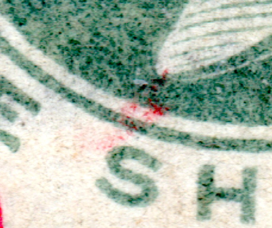 Close-up of stray carmine above the S of SHILLING on GB 1900 1s broken plate variety.